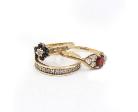 Three 9ct gold stone set rings, to include a sapphire and diamond flower head ring, eternity ring and one other, all stamped 