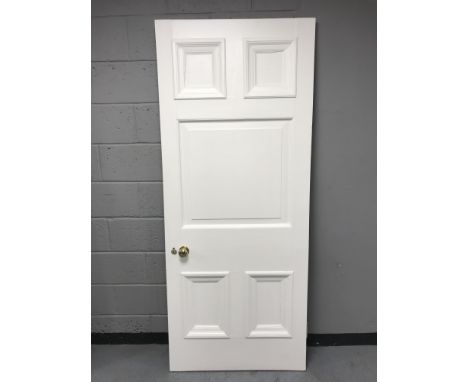 A painted interior panel door with brass handle 