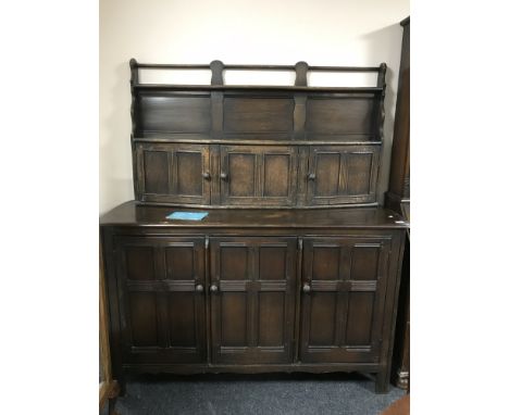 An Ercol triple door sideboard fitted with cupboards and plate rack above 