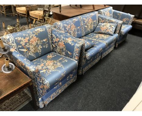 A three piece lounge suite upholstered in blue floral print depicting birds 