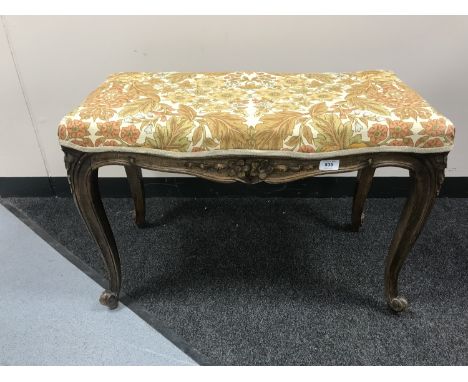 A carved walnut dressing table stool