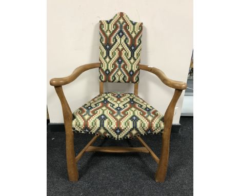 An early twentieth century continental oak armchair upholstered in multi-coloured print 