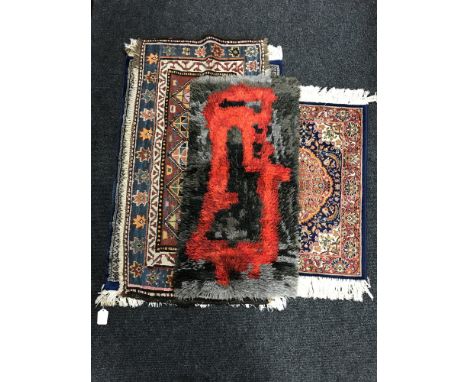 A hearth rug together with a blue silk finished prayer rug and two fringed woollen rugs 