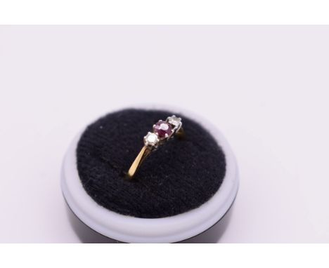 A three stone ruby and diamond gold ring, stamped 18ct and plat, 2.8g. 