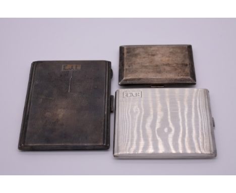 Three various silver engine turned cigarette cases, 389.5g all in. 