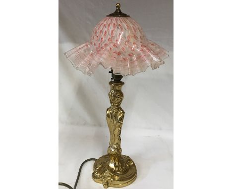 A heavy brass table lamp with a glass fluted red and white shade. Ht to top of shade approx. 47cm, base 13cm d. 