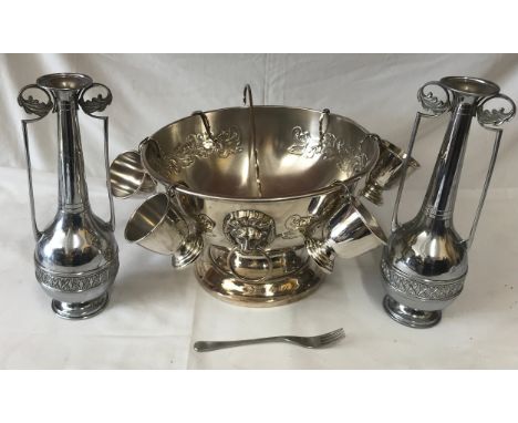 A chrome large punch bowl with cups and ladle along with two chrome vases and a fork. Punch bowl diameter 32cm, vase 32cm h. 