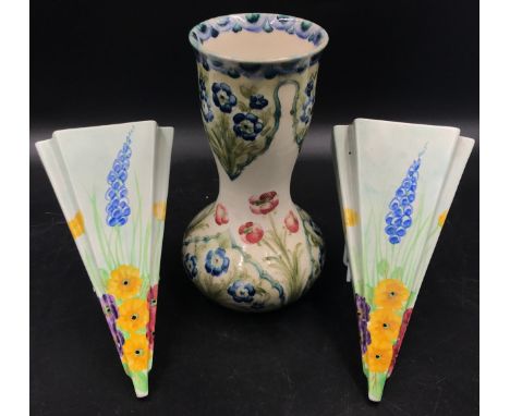 A William Moorcroft Macintyre Burslem vase with floral design 21 h and a pair of hand painted hollow wall hangings signed on 