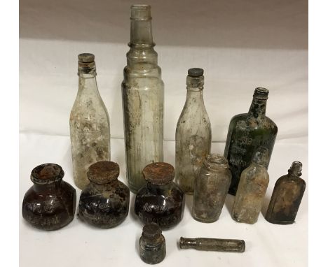 A collection of glass bottles to include three 16oz Bovril, Gordon's special dry London gin and an Essotube tall bottle measu