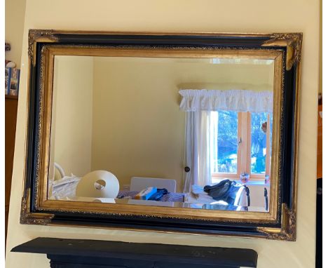A modern black and gilt bevelled edge wall mirror 80 h x 110cm w. 