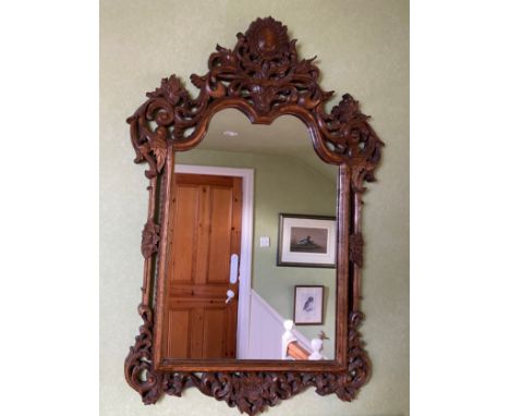 A decorative carved oak wall mirror. 