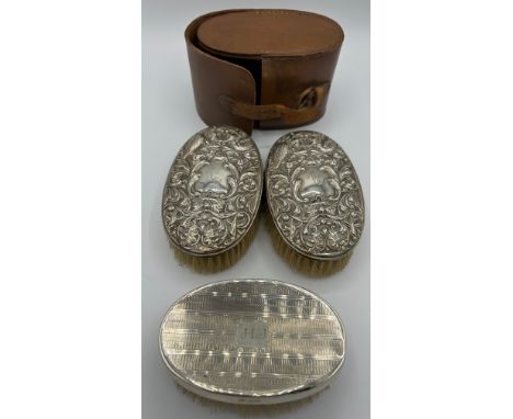 A pair of gentleman's silver backed hairbrushes in original  leather case Chester 1931 together with another silver hairbrush