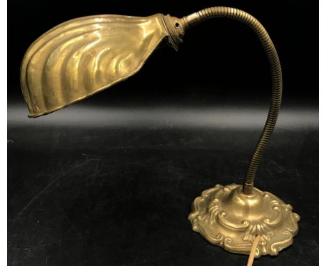 A brass desk lamp with shell shaped shade and adjustable neck measuring 55cm h. 