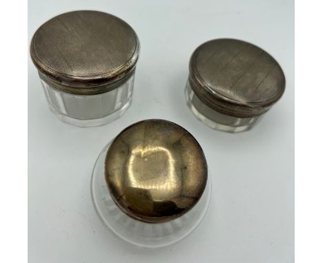 Three silver topped glass jars. Two with engine turned decoration, Birmingham 1936, maker Adie brothers Ltd. 