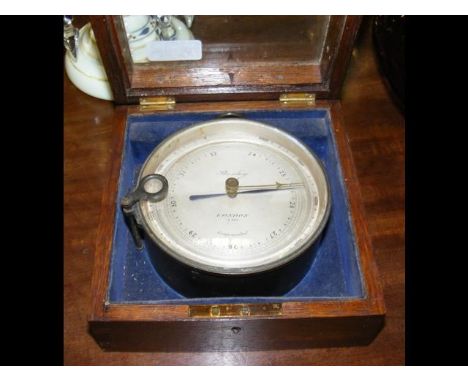 An oak glazed compensated aneroid barometer by Stanley of London