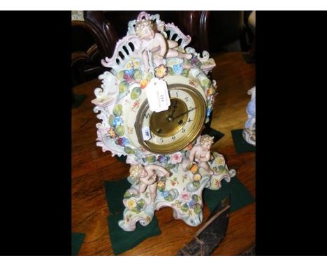 A striking mantle clock in ornate cherub and flower encrusted porcelain caseCONDITION REPORTsigns of loss to fingers of cheru