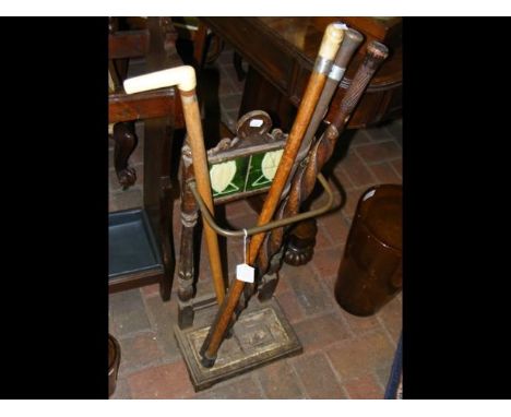 An antique stick/umbrella stand, together with four walking sticks