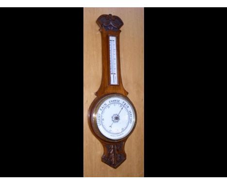 A carved oak barometer/thermometer