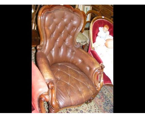 A Victorian mahogany framed library armchair with deep button back, armrests and seat in tan leather