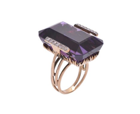 An amethyst and diamond dress ring, the step cut amethyst with canted corners, estimated to weigh 41.61 carats, flanked by tw