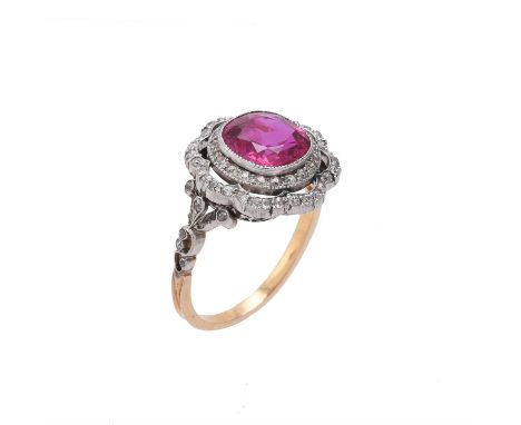 An Edwardian Burma ruby and diamond cluster ring, circa 1910, the cushion cut ruby estimated to weigh 3.00 carats within a pi