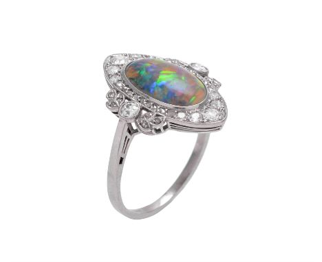 A Edwardian black opal and diamond panel ring, circa 1910, the oval cabochon opal measuring 12.8mm x 8mm within an old cut an