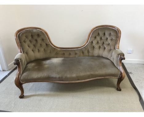 A Victorian carved walnut framed button back double spoon back sofa, the moulded show frame with scroll arms, raised on scrol