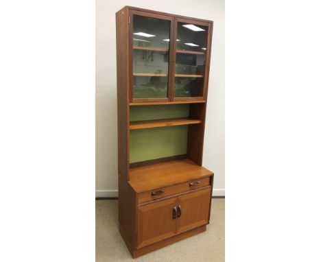 A G Plan teak display cabinet with two glazed doors over a shelf and a recess on a base with single drawer over two cupboard 