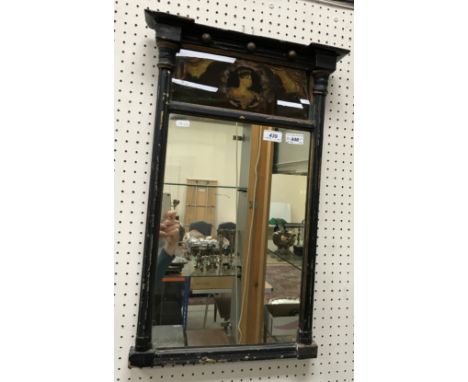 An early 19th Century pier glass with ebonised and gilt decoration, the top panel with reverse glass painting depicting a wom