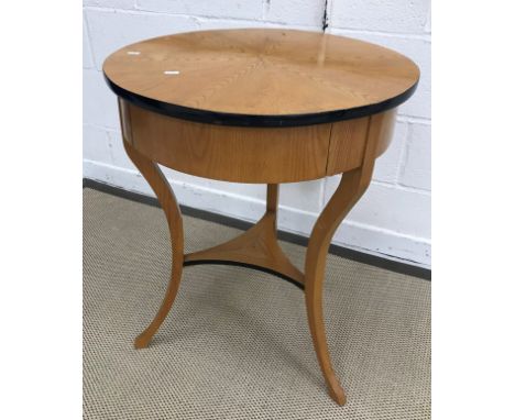 An oak and ebonised occasional table in the Biedermeier taste, the segmented top within a lacquered banding over a single fri