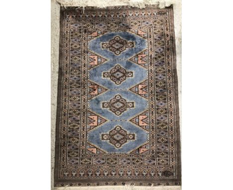 A Bokhara rug, the central panel set with four repeating medallions on a pale blue ground, within a stepped pale blue, lilac 