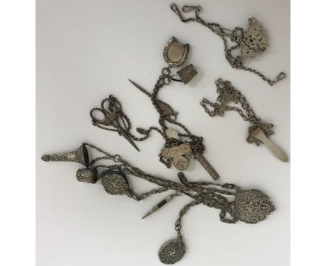 A Victorian silver plated chatelaine with five hanging chains, each supporting a different item comprising cushion, thimble, 