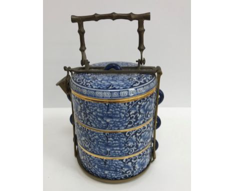 A 20th Century Thai blue and white and gilt decorated tiffin in three sections with all over scrolling foliate and floral dec