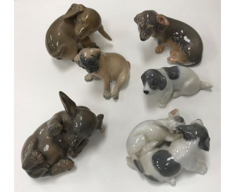 A collection of six various Royal Copenhagen dog / puppy figures including "Puppy chasing tail" (1407), "Puppy on side" (1408