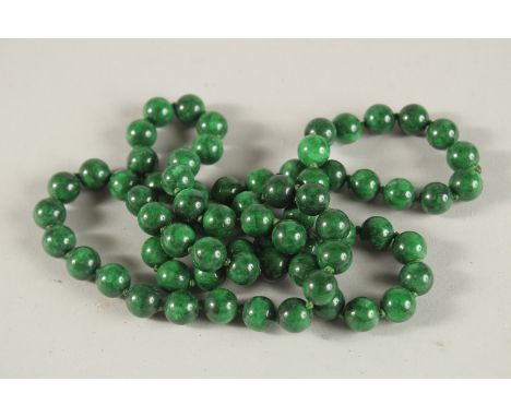 A STRING OF JADE BEADS. 80cms long.