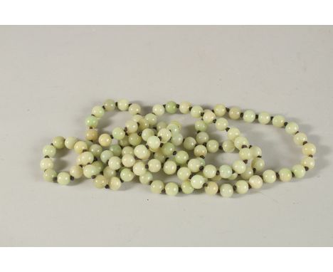 A LONG STRING OF JADE BEADS. 130cms long.