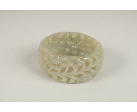 A PIERCED CELADON JADE BANGLE. 7cms diameter.