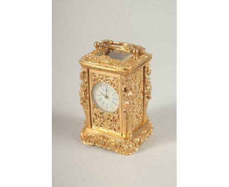 A SMALL ORNATE GILT METAL CARRIAGE CLOCK in an ornate case with female nudes. 6.5cms high.