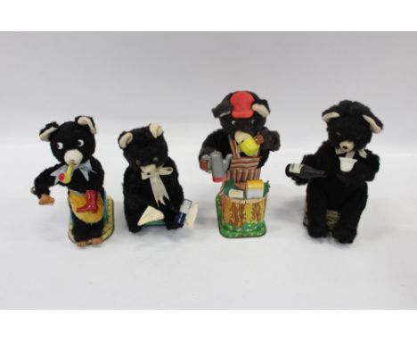 Group of four vintage battery-operated automaton black bears, performing various actions - including shoe-shining, drinking, 