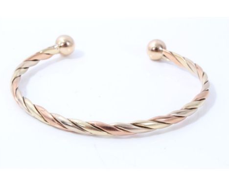 Three-colour gold (9ct) ropetwist torque bangle CONDITION REPORT Total gross weight approximately 14.2 grams.Bangle currently