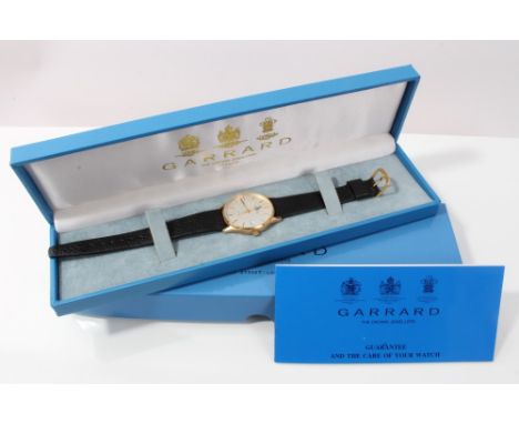 Garrard gold (9ct) cased quartz wristwatch with circular dial, baton markers and date aperture, on black leather strap, with 