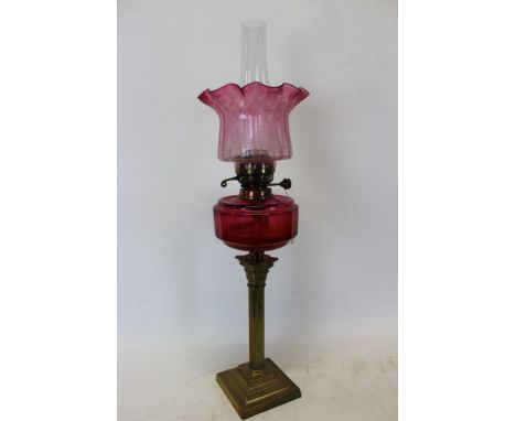 Late 19th / early 20th century oil lamp with 'British Made' burner, cranberry glass reservoir, on a brass Corinthian column a