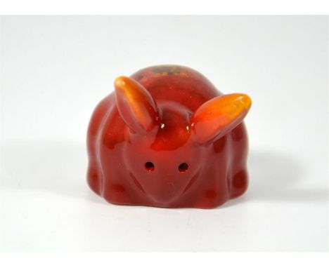 A Bernard Moore miniature model of a rabbit, covered in a red lustre, flambe glaze. BM monogram inside base. Height 2.5cm.