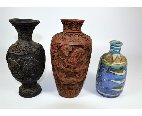 Three vases, including two resin carved and one ceramic. Chinese dragon, floral and fish patterns. Height of tallest vase 23c