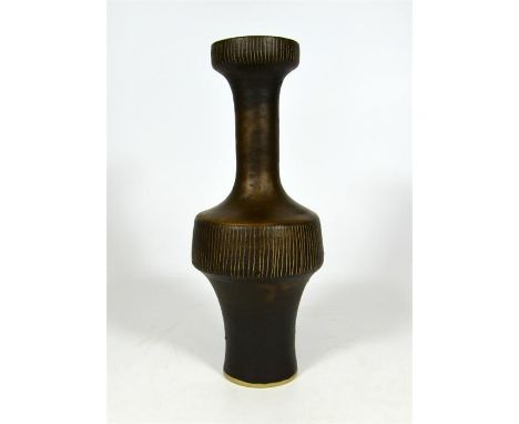 † A Lucie Rie porcelain vase with a manganese glaze. With a band of sgraffito around the waist and outer and inner of the lip