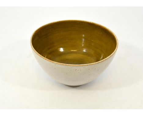 † A Lucie Rie and Hans Coper bowl, with an oatmeal exterior glaze and an olive green interior. Lucy Rie and Hans Coper seals.