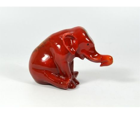 A Bernard Moore model of a seated elephant covered in a red lustre, flambe glaze. BM monogram to base. Height 8.5cm.