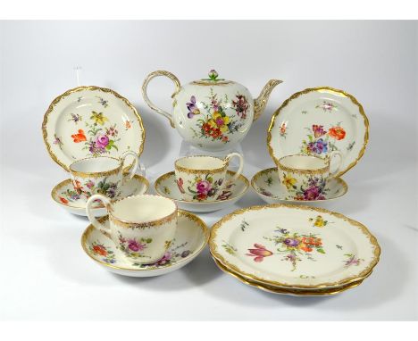 A Meissen teapot and four cups and saucers with four side plates, scored mark painted with floral sprays. Swan necked handles