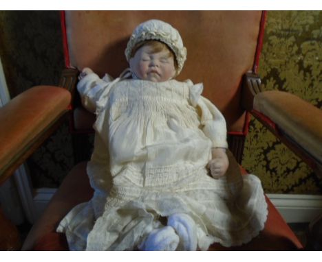 A 1983 bisque faced cloth body doll 22 inches 'first movements' by Lee Middleton doll company. dressed in white with matching