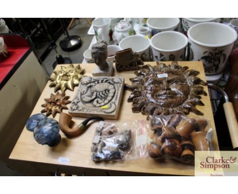 A quantity of wooden mushrooms, soap stone figures wall plaques in the shape of the sung, a pipe etc.